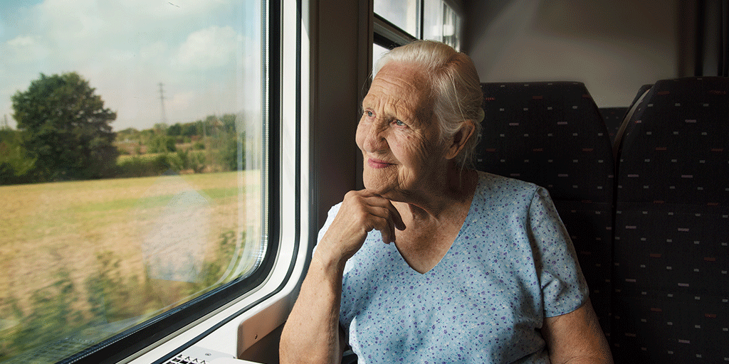A person looks out the window while travelling on a train.